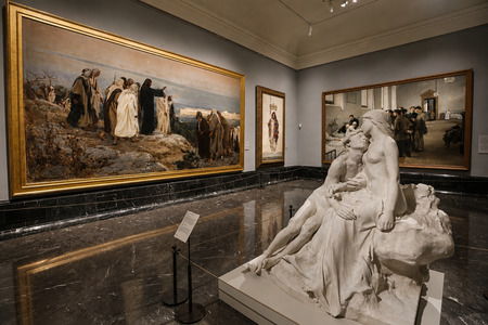 Gallery at the Prado Museum featuring paintings from different periods and a marble sculpture